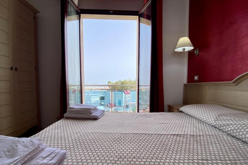 una camera con due letti e una grande finestra di B&B Marina Sleep And Ship a Rodi Garganico