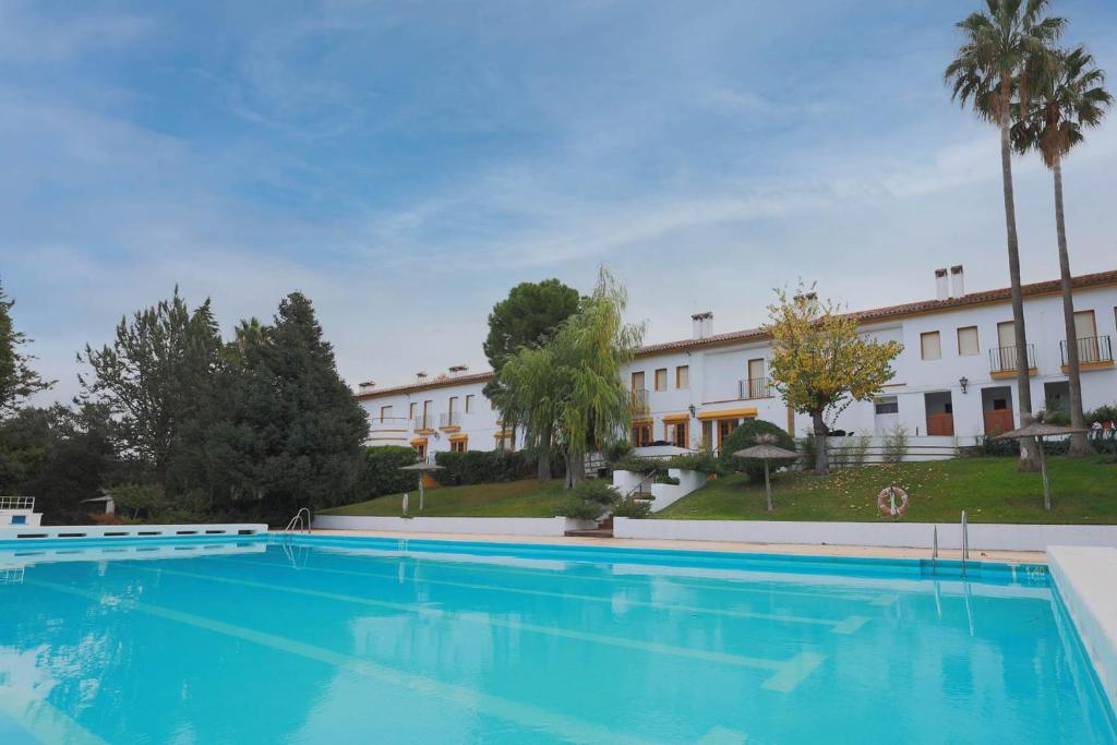 a large swimming pool in front of a building at Hotel Tugasa El Almendral in Setenil