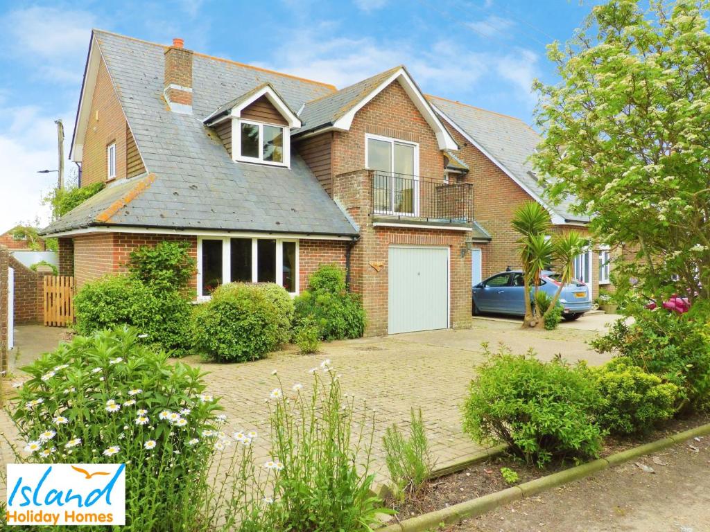 une maison en briques avec une voiture garée dans l'allée dans l'établissement Gate House, à Bembridge