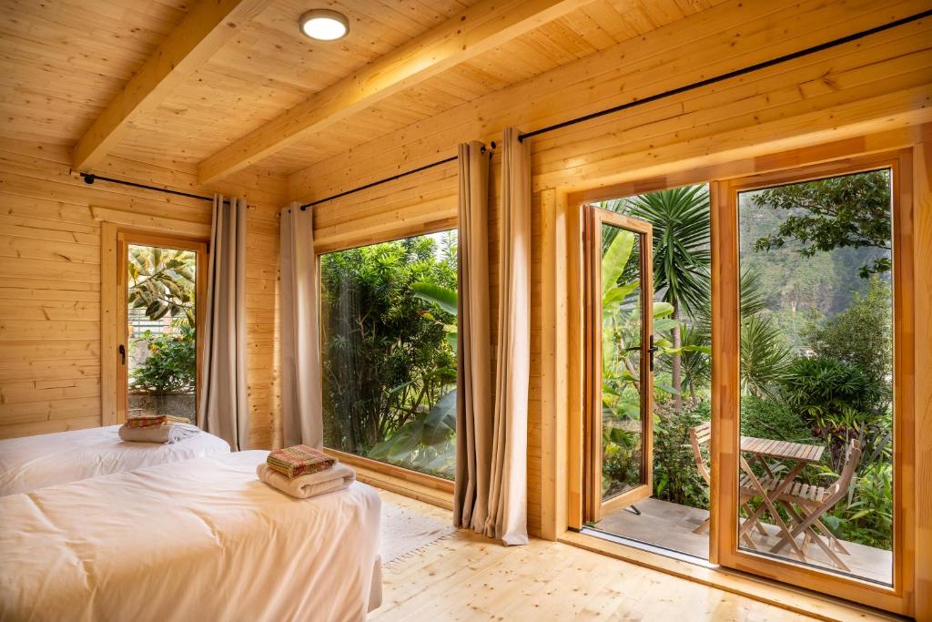 - une chambre avec un lit et une grande fenêtre dans l'établissement Garden bungalow, à São Vicente