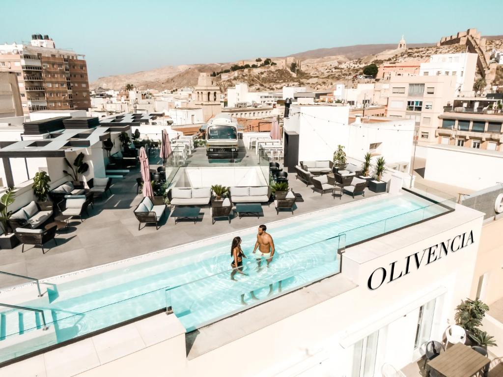 duas pessoas numa piscina no topo de um edifício em HO Puerta de Purchena em Almeria