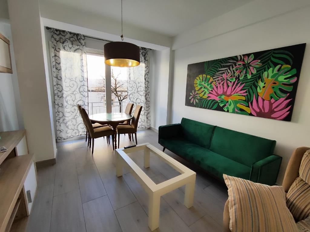 a living room with a green couch and a table at La casa del mercado in Córdoba