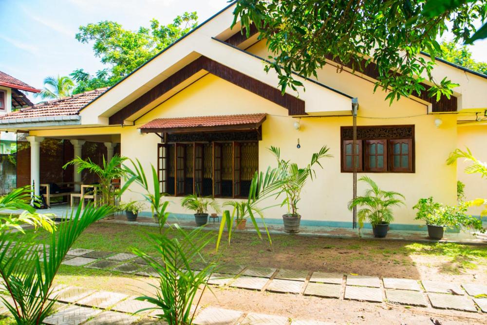 a yellow house with plants in front of it at The Villa Marcelle in Negombo
