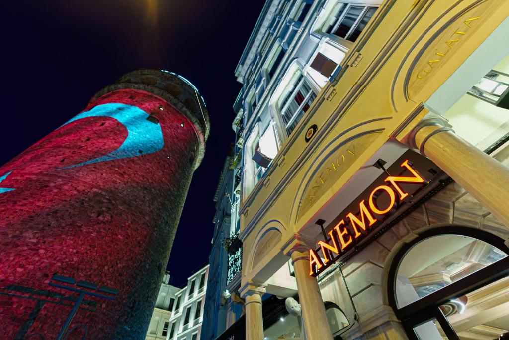 ein Gebäude mit einem Turm und einem daneben stehenden Schild in der Unterkunft Anemon Koleksiyon Galata Otel in Istanbul