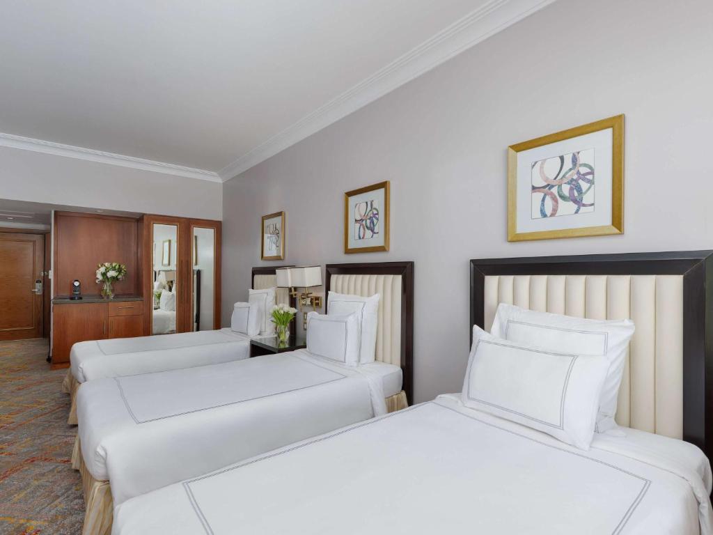 two beds in a hotel room with white pillows at Swissotel Al Maqam Makkah in Mecca