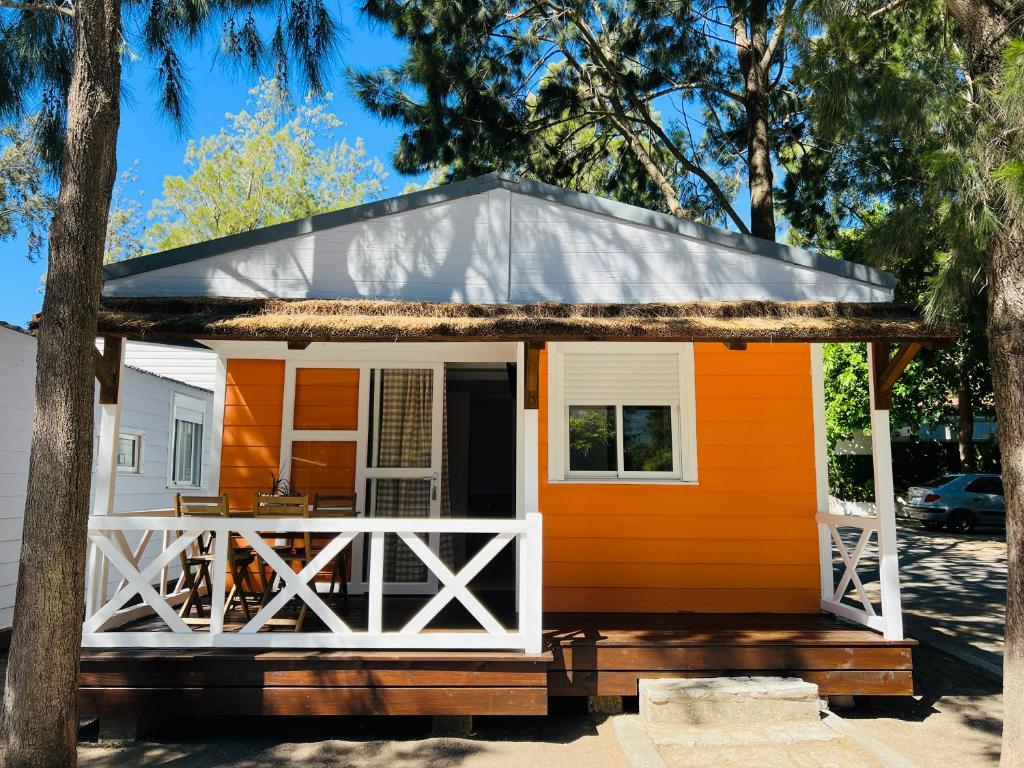 uma pequena casa com um exterior laranja e branco em Camping Paloma em Tarifa