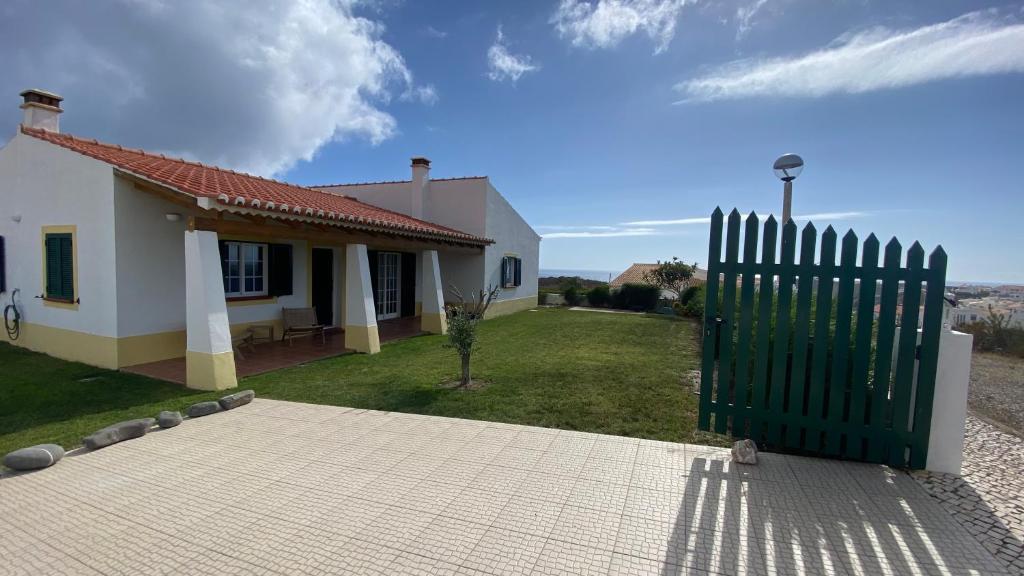 a house with a green gate in front of it at Arrifana Beach Break in Aljezur