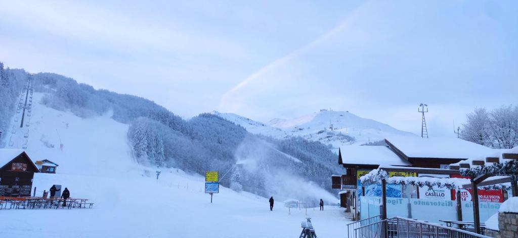 a snow covered ski resort with people on a ski slope at Loft Mag in Fanano