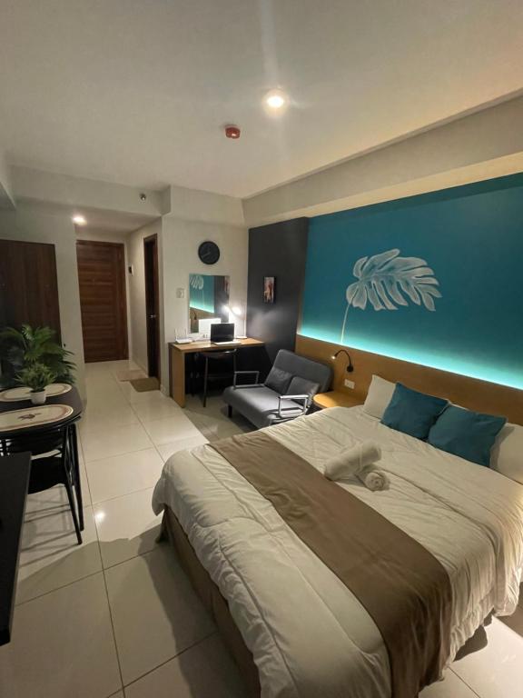 a bedroom with a large bed with a blue wall at MG’s PLACE at Horizons 101 in Cebu City
