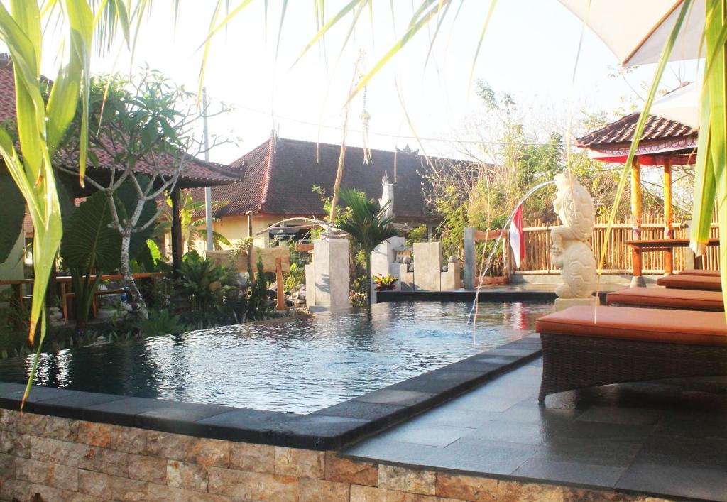 una piscina con una fuente en un patio en The Akah Cottage - CHSE Certified en Nusa Lembongan
