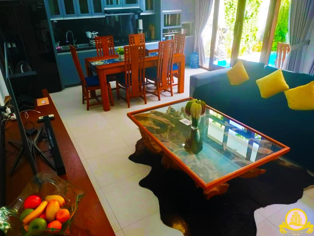 サヌールにある3Bedroom Villa Kepiting Sanurのリビングルーム(テーブル、青いソファ付)