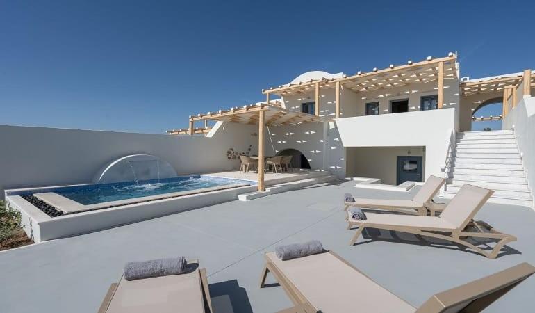 eine Villa mit einem Pool und einigen Stühlen in der Unterkunft Beautiful Santorini Villa - 3 Bedroom Villa - Private Jacuzzi and Charismatic Interior - Vothonas in Agia Paraskevi
