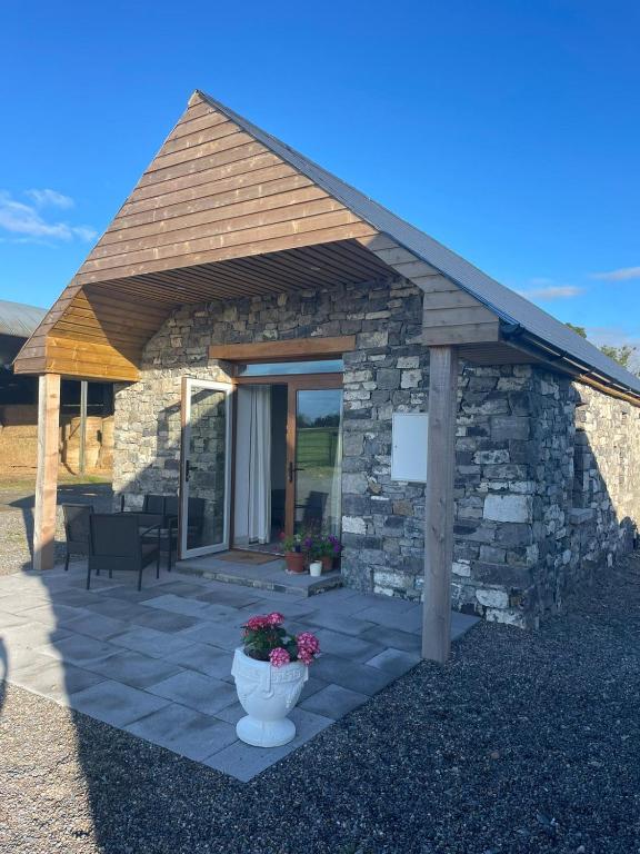 a stone building with a porch with a pot of flowers at Welcome to DC's Cottage in Holycross