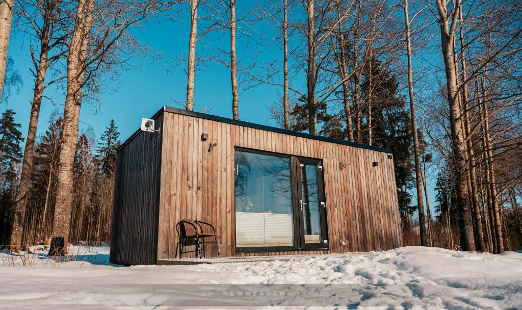 eine kleine Hütte mit einem Stuhl im Schnee in der Unterkunft Juusa cabin in Otepää