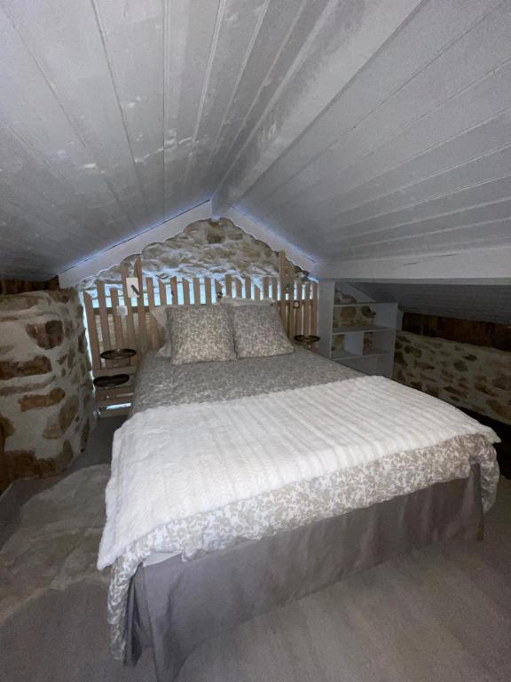 a bedroom with a large bed in a attic at Séjour à la Marronnie in Saint-Germain-les-Vergnes