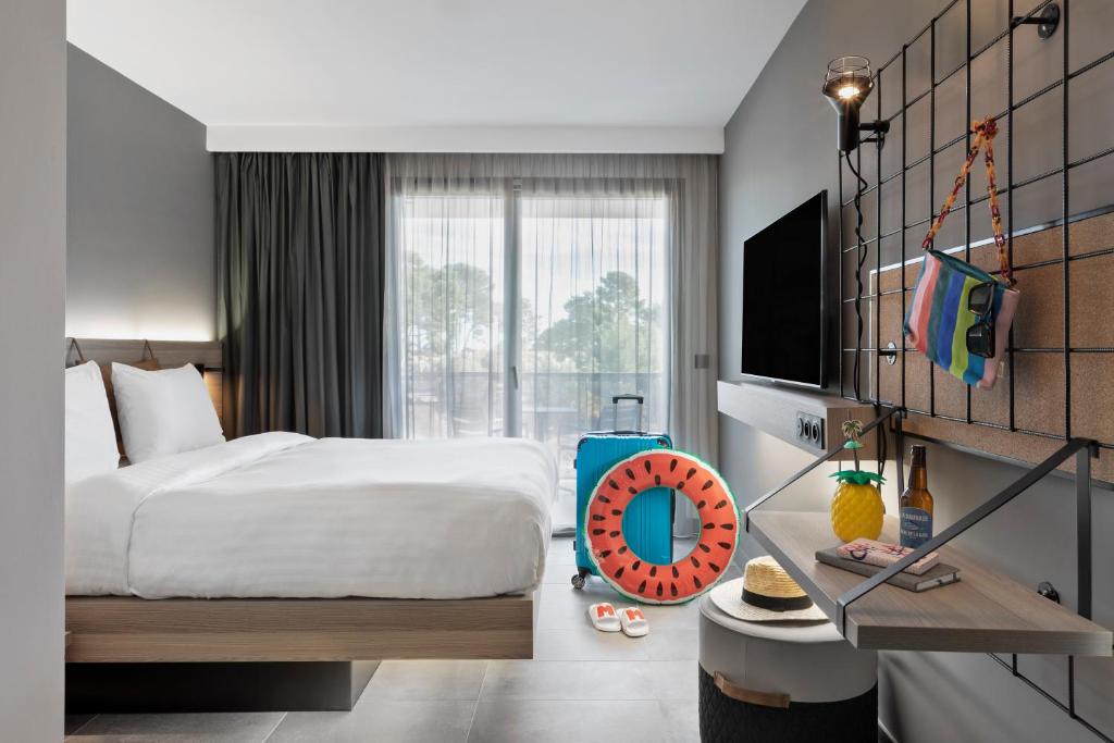 a hotel room with a bed and a large window at Moxy La Ciotat in La Ciotat