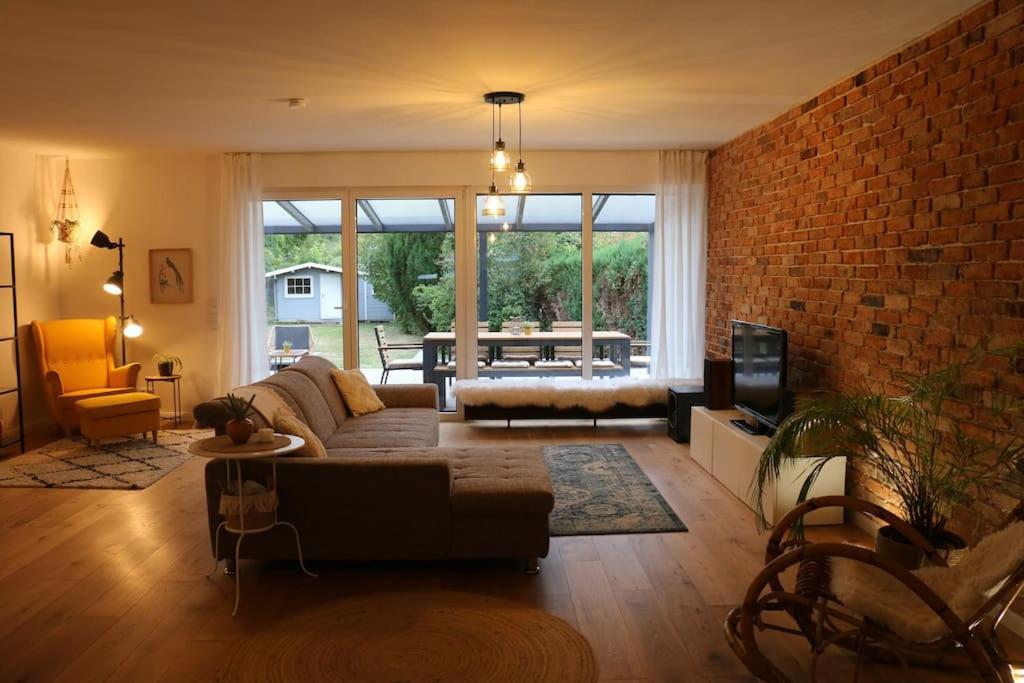 a living room with a couch and a brick wall at Gemütliches Traumhaus im Grünen in Swisttal