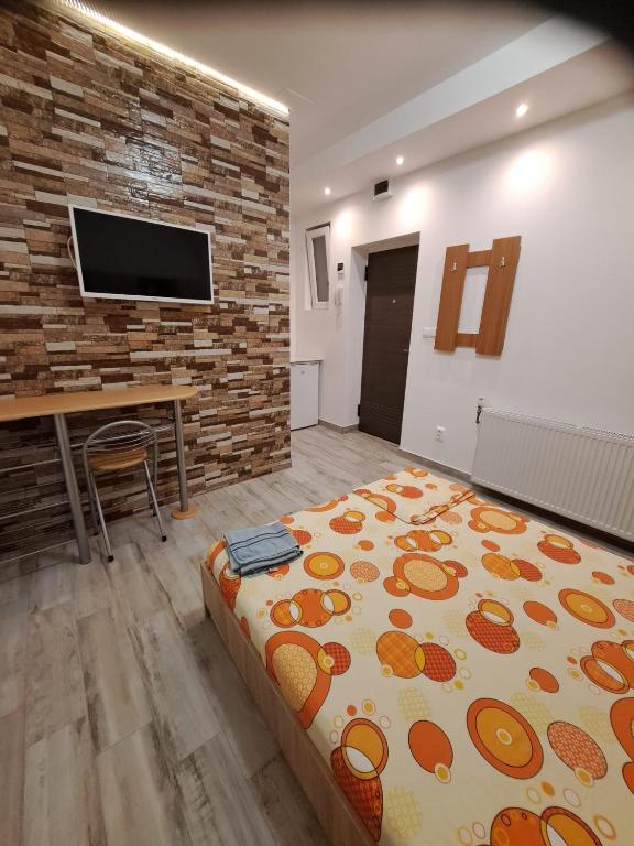 a room with a bed and a table and a tv at Memorandului Residence in Timişoara