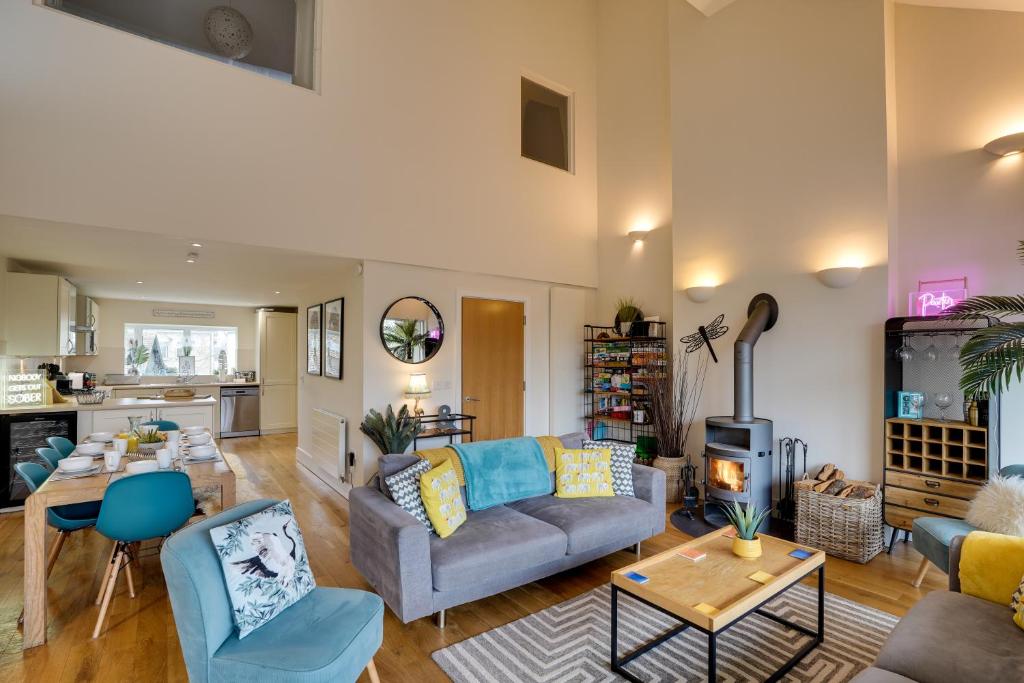 ein Wohnzimmer mit Sofa und Tisch in der Unterkunft Eider Cottage Lakeside Escape with Spa Access in Cirencester