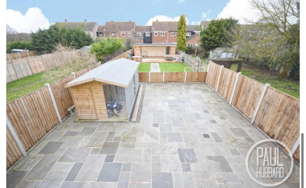 a backyard with a dog house on a patio at Immaculate 3-Bed House in Bungay in Bungay