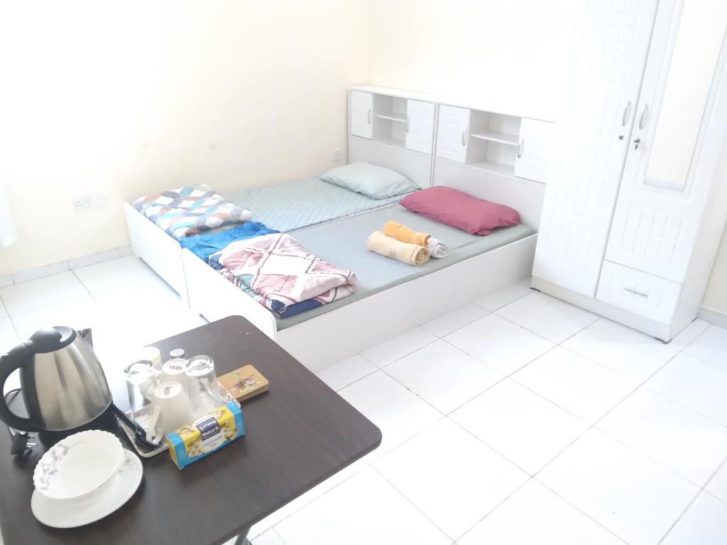 mały pokój z łóżkiem i stołem w obiekcie Daily stay Royal flat w Dubaju