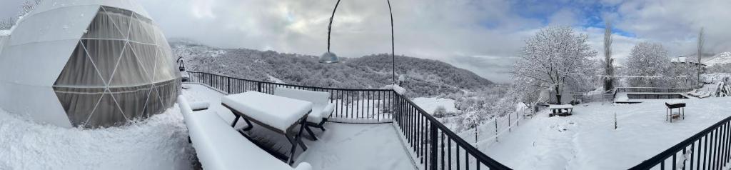 un balcón cubierto de nieve de un lodge de esquí con nieve en Dream Domes Glamping en Gabala