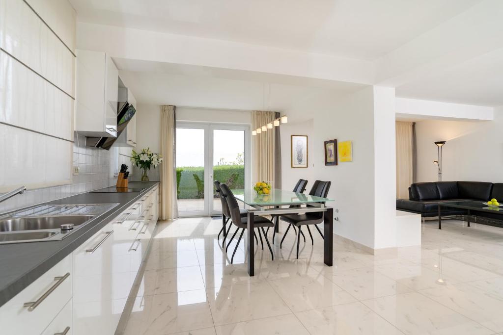 a kitchen with a table and chairs in a kitchen at Spacious modern One bedroom Apartment with Garden & SeaView in Rab