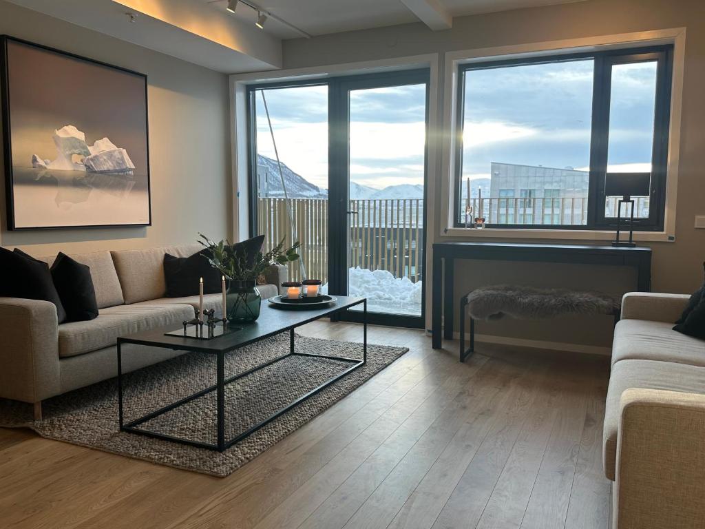 a living room with a couch and a table at TheNorthernExplorer Penthouse in Tromsø