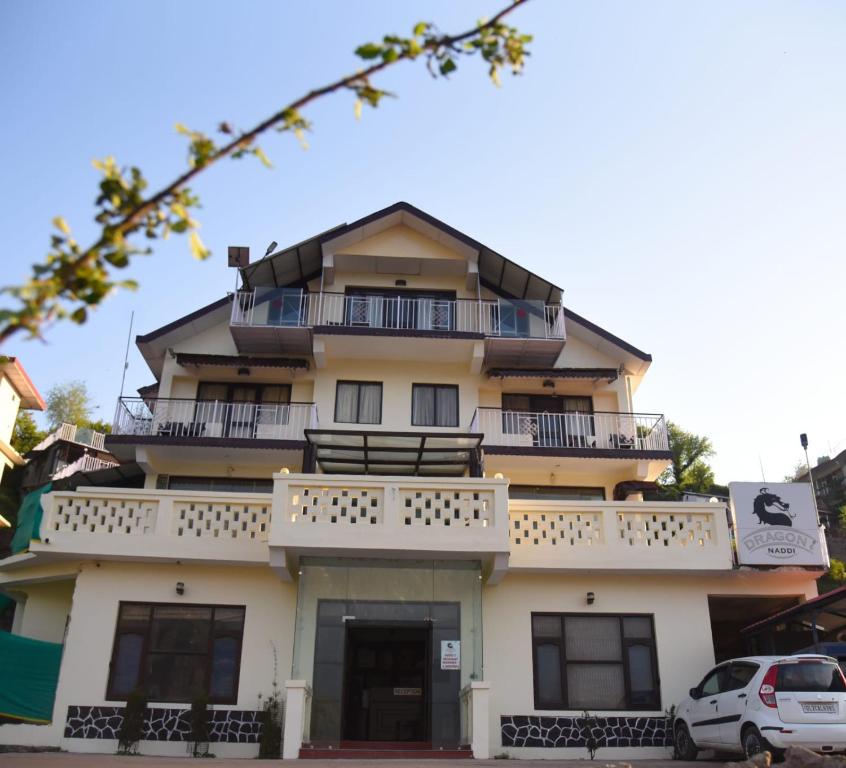 a building with a balcony on the side of it at Dragon I Resorts in McLeod Ganj