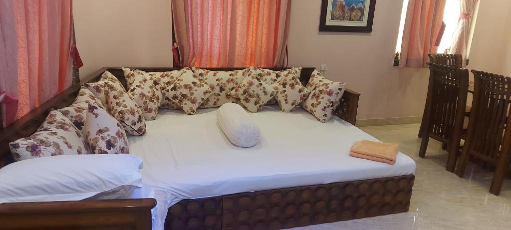 uma cama numa sala de estar com almofadas em Varsha residency em Puri