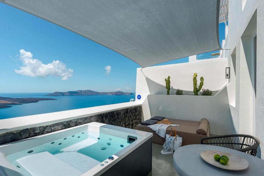 a balcony with a jacuzzi tub in a house at Luxurious Santorini Masionette Villa - 1 Bedroom - Astounding Caldera Sea Views and Private Outdoor Hot Tub - Fira in Fira