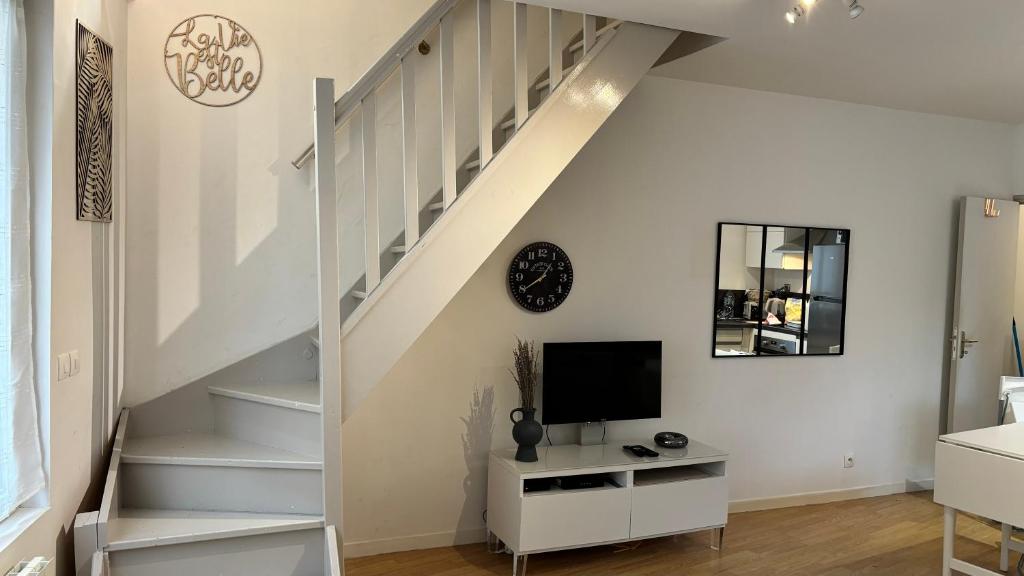 - un salon avec un escalier blanc et une télévision dans l'établissement Ibiscus-Immoploc, à Dieppe