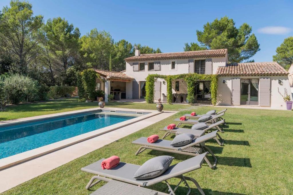 a row of chaise lounge chairs next to a pool at high standard provencal bastide with heated pool in lourmarin in the luberon, vaucluse. 10 people in Lourmarin