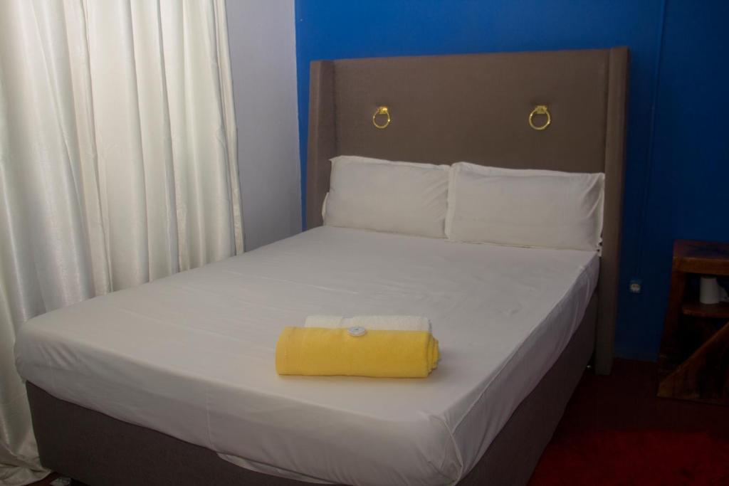 ein Schlafzimmer mit einem Bett und einem gelben Kasten darauf in der Unterkunft Platina House in Maputo