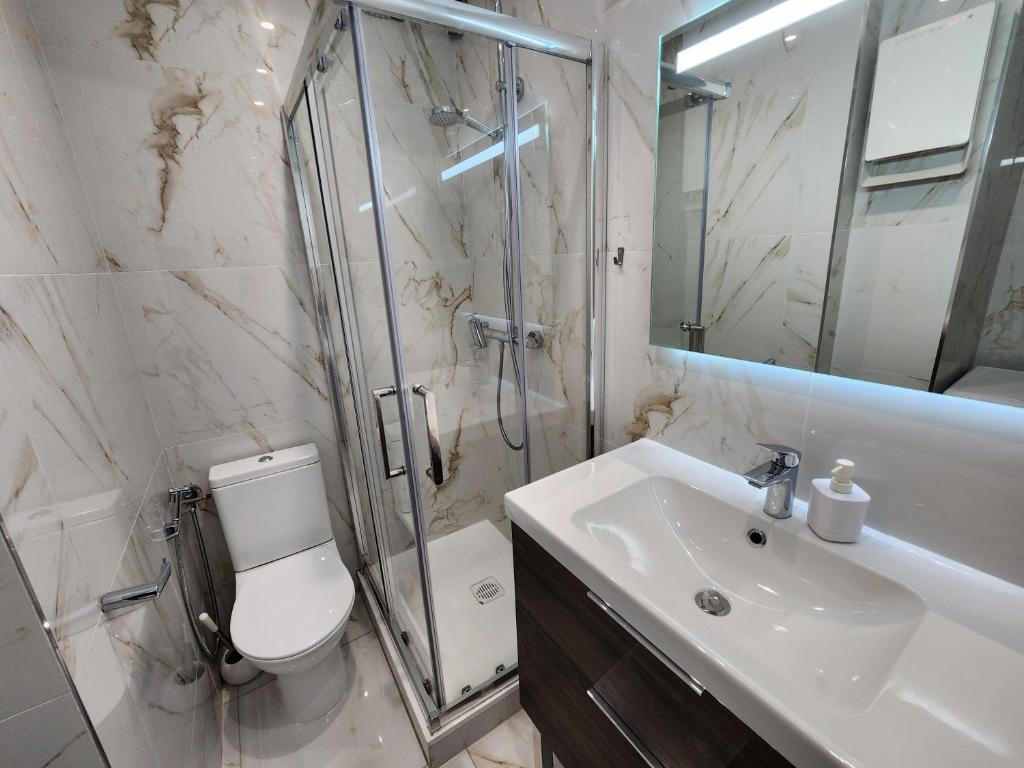 uma casa de banho com um chuveiro, um WC e um lavatório. em Venus - Climatisé - Marina Baie des Anges em Villeneuve-Loubet