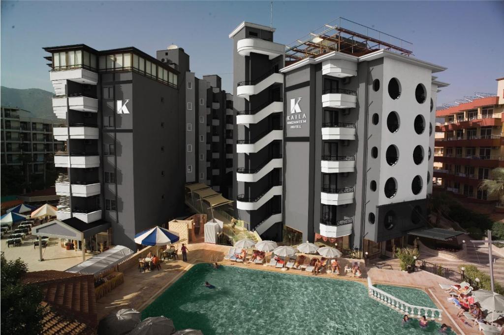 un hotel con una piscina al lado de dos edificios altos en Kaila Krizantem Hotel, en Alanya