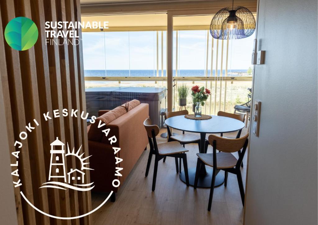 a dining room with a table and chairs and a view of the ocean at Marina Resort A5 in Kalajoki
