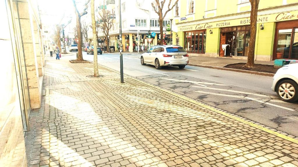 Un'auto bianca sta guidando lungo una strada di città di Townhouse CityCentre a Klagenfurt