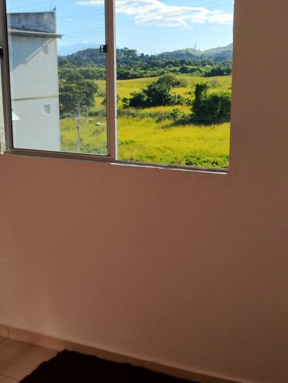 a window with a view of a green field at Apartamento Cabuçu in Nova Iguaçu