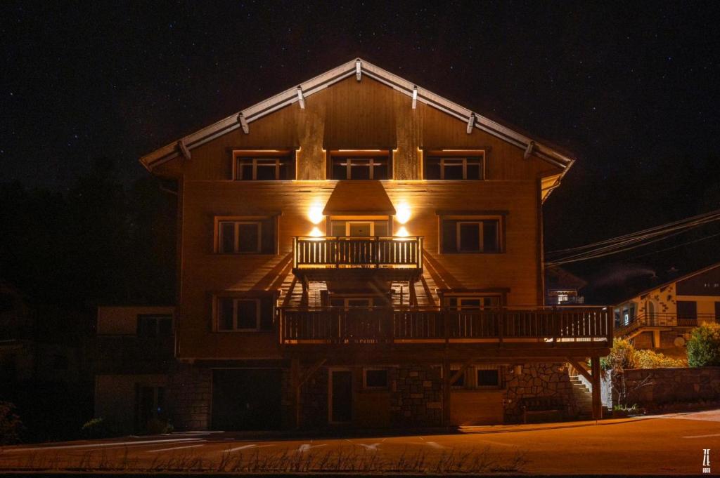 ein großes Gebäude mit Balkon in der Nacht in der Unterkunft la grande cabane du Blanc Ruxel in Xonrupt-Longemer