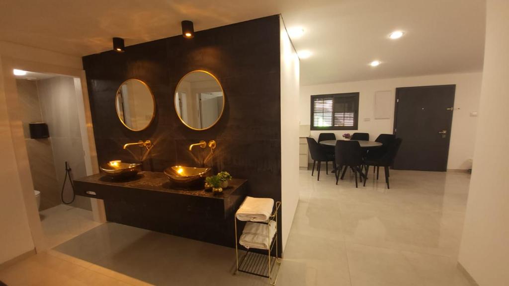 een woonkamer met een tafel en een spiegel bij Y.L אירוח בוטיק in Bet Sheʼan
