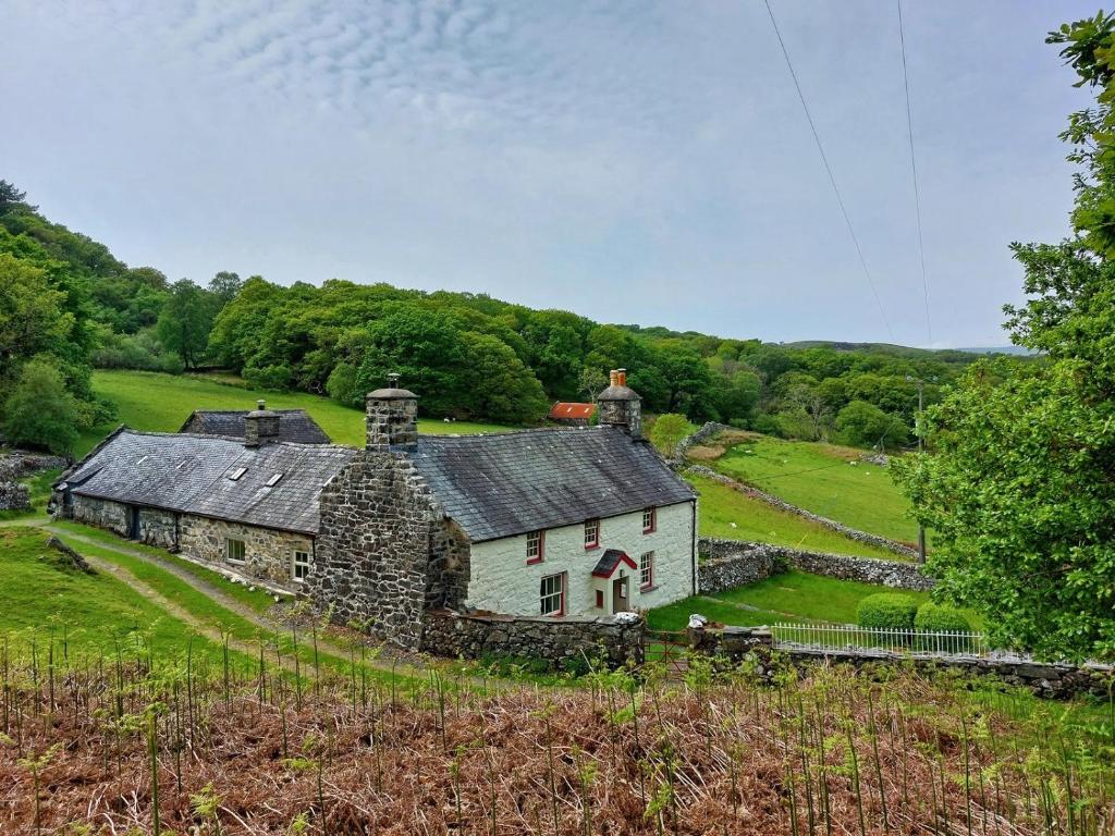 an old stone house in a grassy field at Gallestra a Rustic, Rural Retreat Farm House Nr Dolgellau Snowdonia in Dolgellau