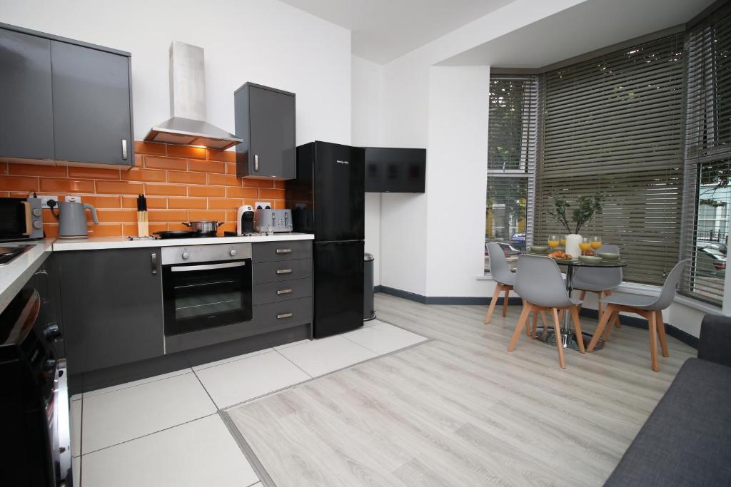 una cocina con electrodomésticos negros y una mesa con sillas. en 101 Walter Road en Swansea