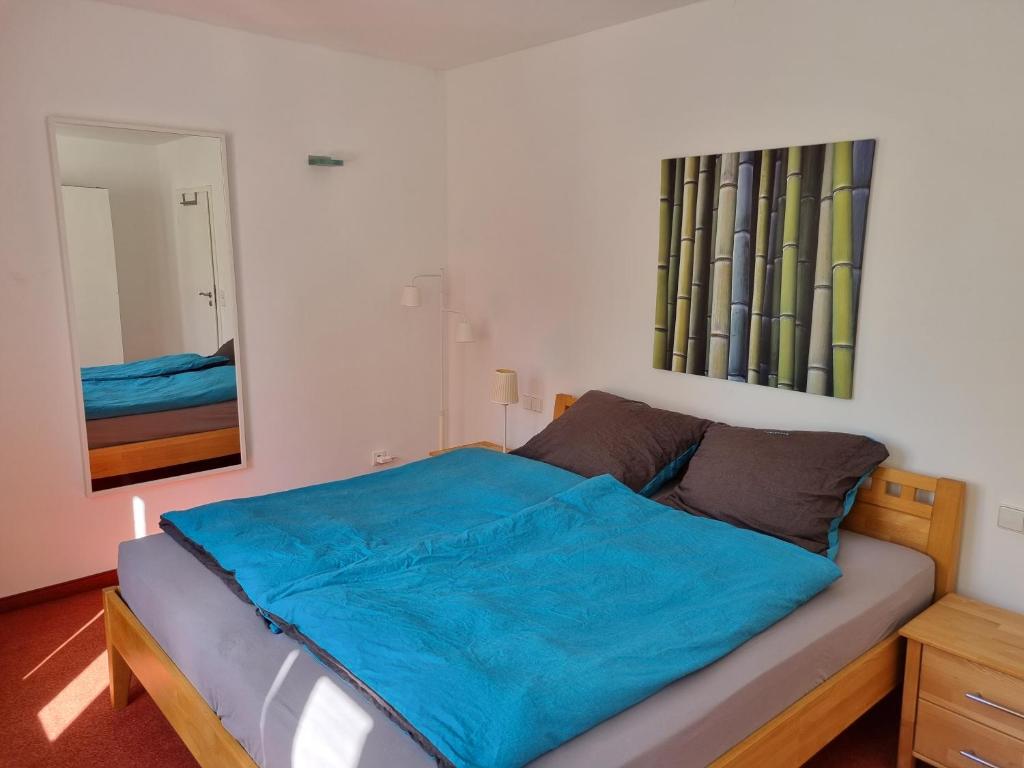 ein Schlafzimmer mit einem Bett mit einer blauen Decke darauf in der Unterkunft BMS BALANCE - Gemütliche 4 Sterne Möblierung neben dem Parkhotel in Wolfsburg