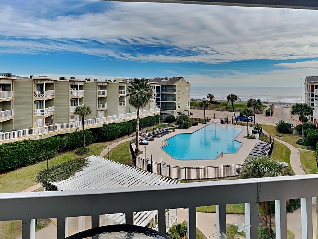 balcone con vista sulla piscina di un resort di Victorian 5302- Oceans Away a Galveston