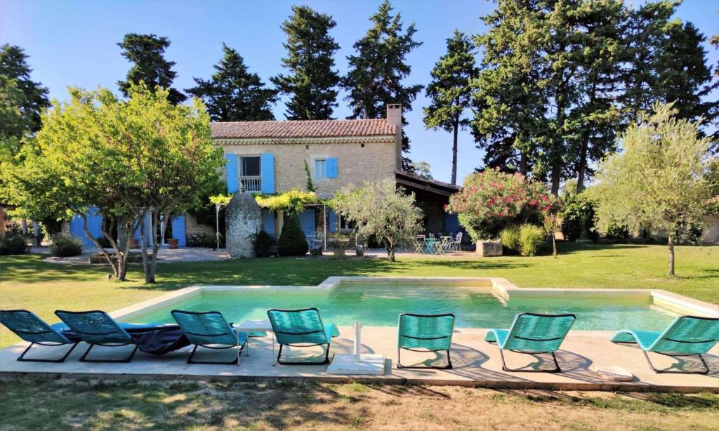 カヴァイヨンにあるvery beautiful provencal mas with pool, in the country, between cavaillon and l'isle sur la sorgue - sleeps 10のスイミングプールの周りに座る椅子