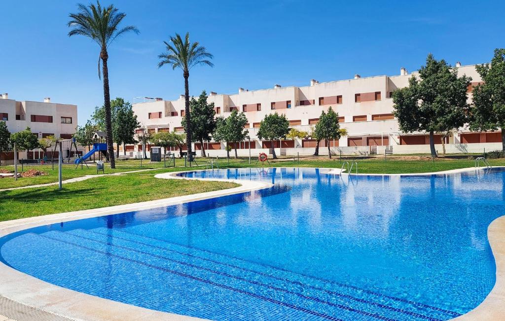een groot zwembad in een park met palmbomen bij House Panoramica Golf Holidays in Sant Jordi