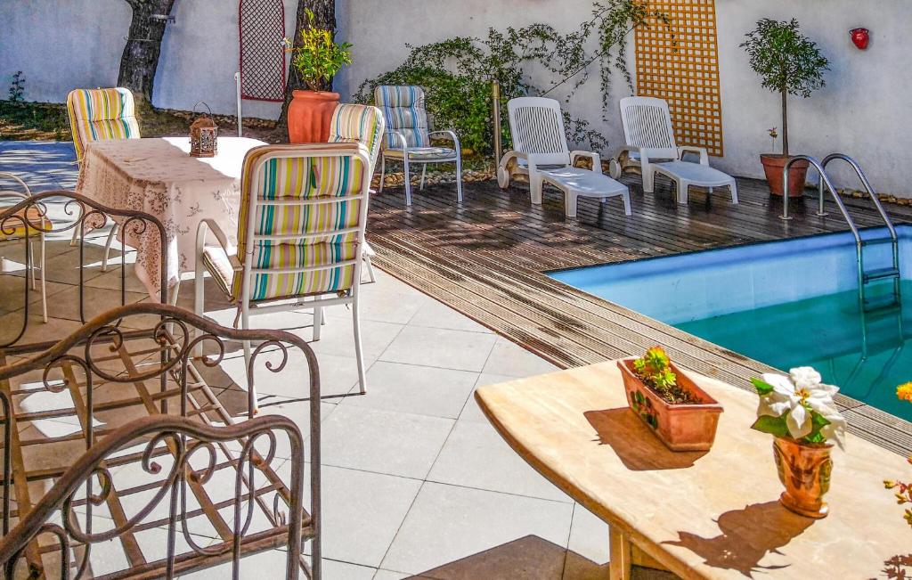 a patio with a table and chairs next to a pool at 3 Bedroom Stunning Home In Caissargues in Caissargues