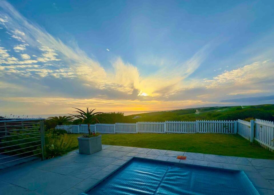 un patio trasero con piscina y valla en Lodge 62 Unparalleled view. en Mossel Bay