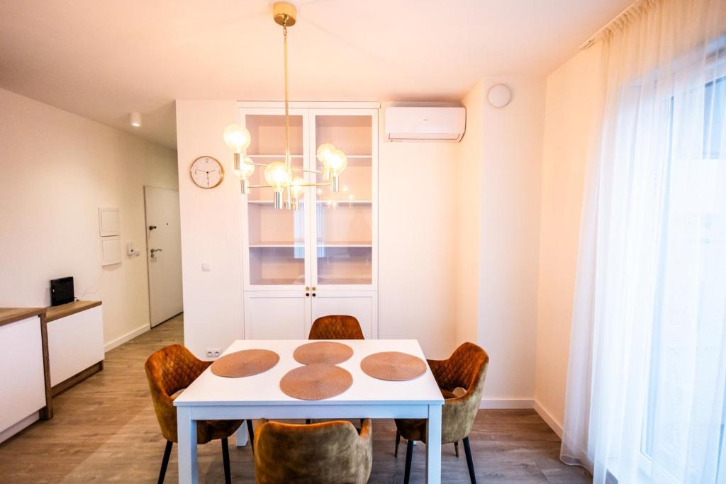 托倫的住宿－Apartament Lotników，一间配备有白色桌椅的用餐室